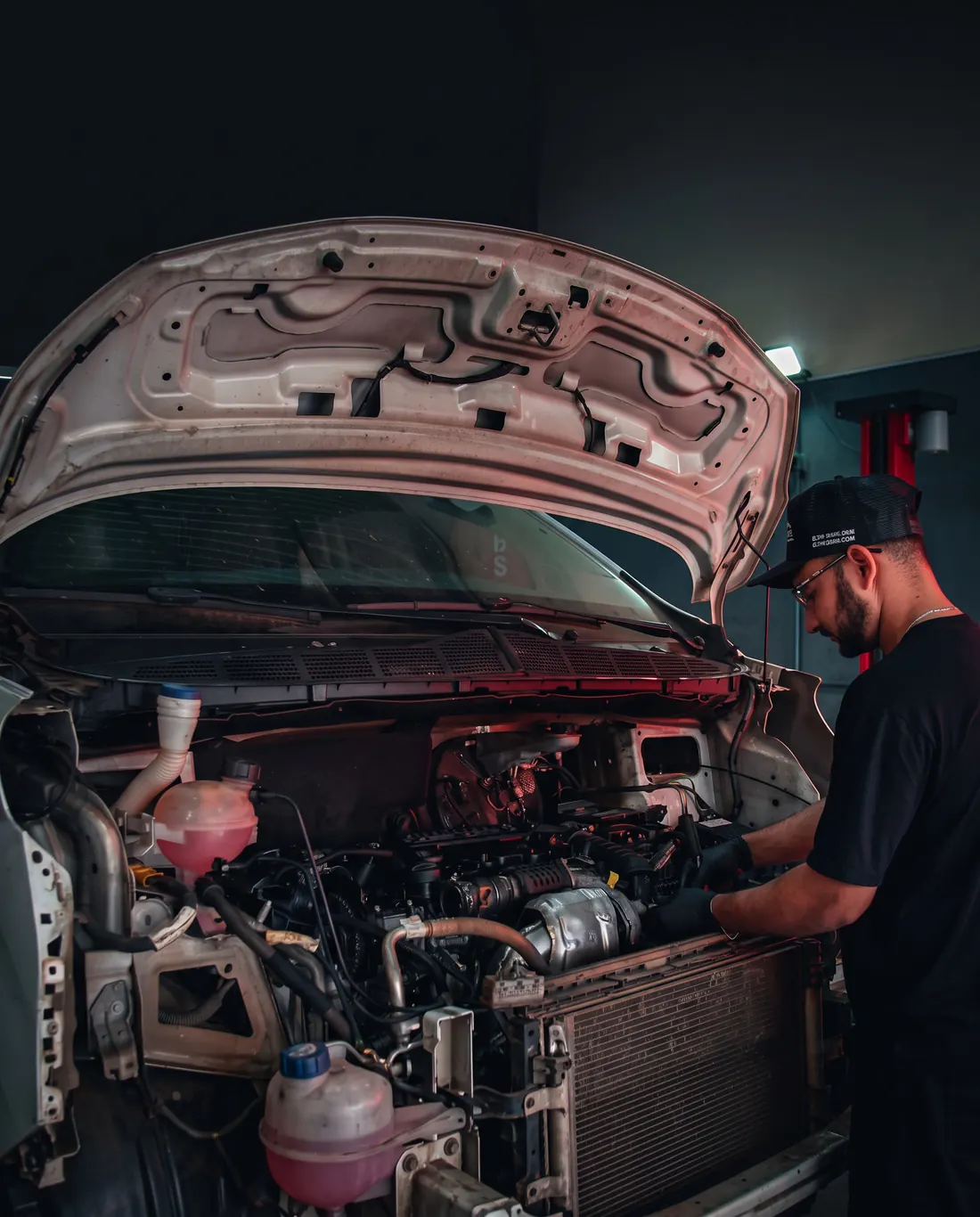 Mecânico da TS Auto Center conferindo correias, fluidos e parte elétrica no motor